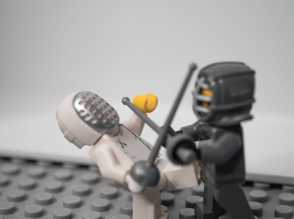 Two lego minifigs settling a conflict through the art of fencing.