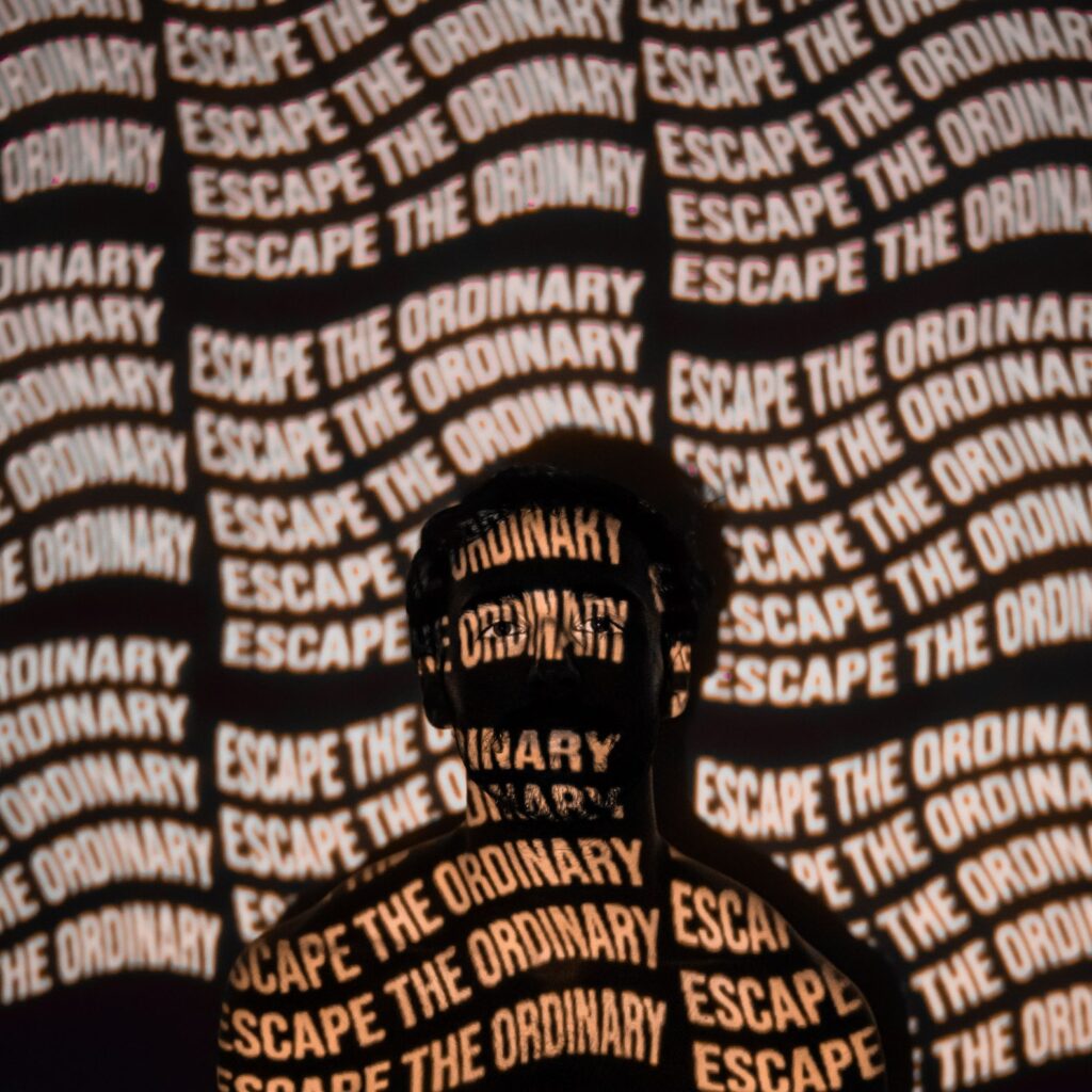 The outline of a person that says "Escape the ordinary"