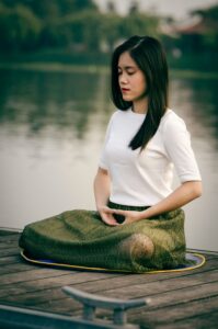 Woman meditating on a dock