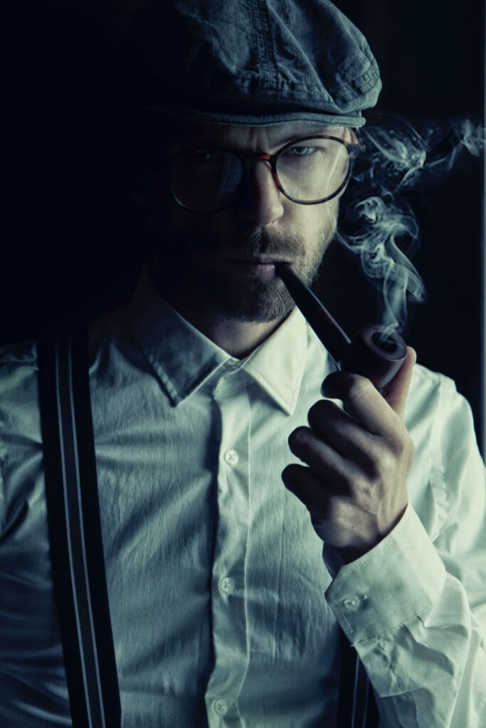 A surly looking man smoking a pipe