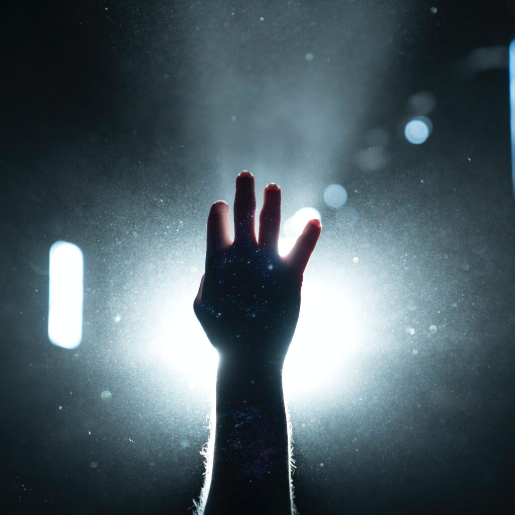 Hand reaching towards a beam of light